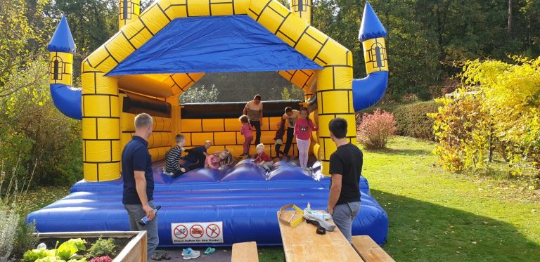 Hüpfburg Verleih Naturfreunde Fürstenfeld Farbenfroher Hüpfburg mit Kindern, die spielen, und Erwachsenen in der Nähe.