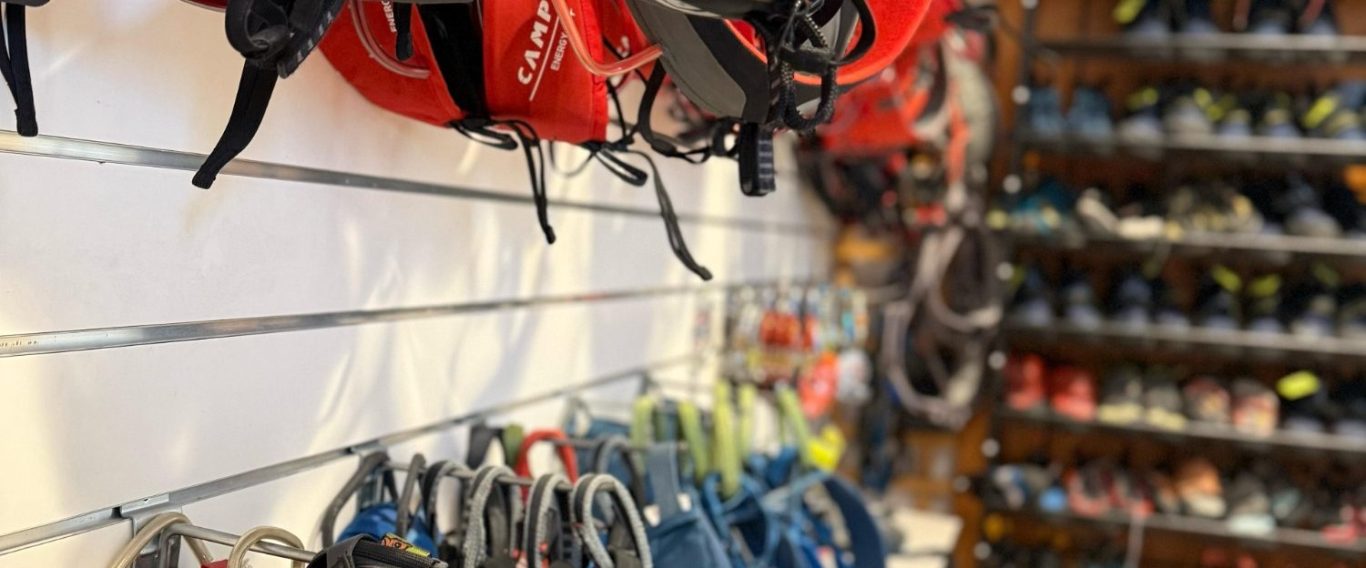 Kletterzubehör-Verleih Farbenfrohe Kletterschuhe und -zubehör an einer Wand ausgestellt.